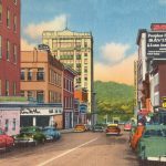 cars parked beside brown concrete building during daytime