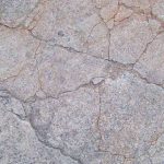 Béton fissuré aux tons grisâtres, craquelé, sans éléments extérieurs