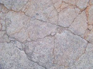 Béton fissuré aux tons grisâtres, craquelé, sans éléments extérieurs