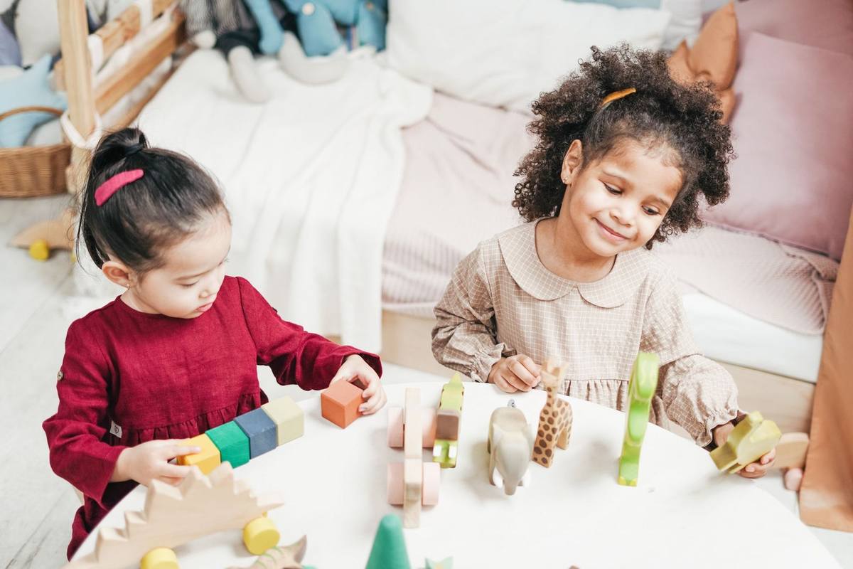Enfants manipulant des blocs en bois sur une table dans une pièce